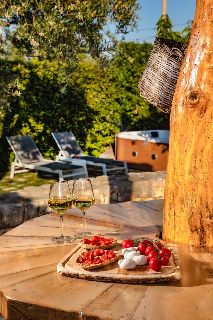 Aperitivo sul tavolo in legno, con i lettini sullo sfondo