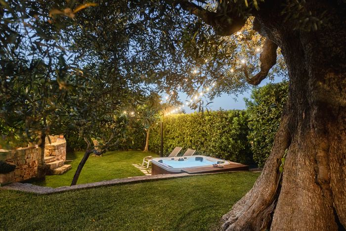 Il giardino la sera, con l’ulivo secolare e la jacuzzi illuminata