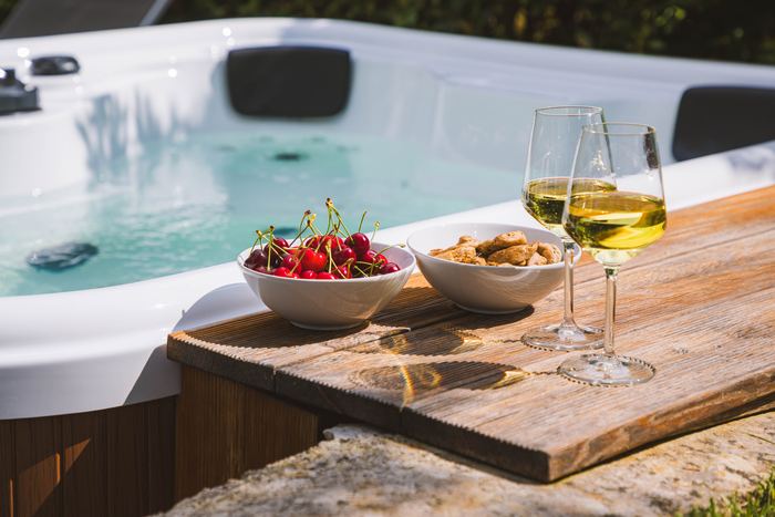 Calici di vino e frutta sul bordo della jacuzzi