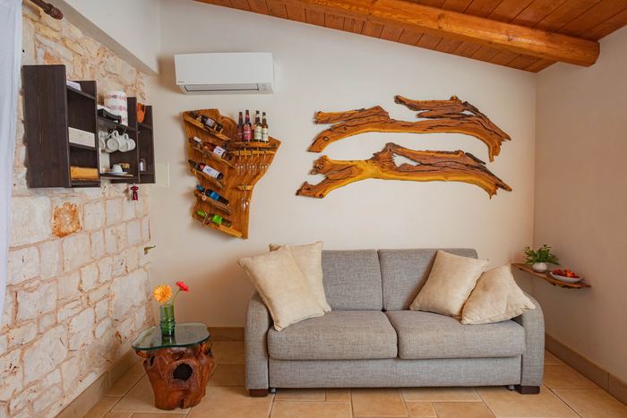 La saletta con il divano e le decorazioni in legno