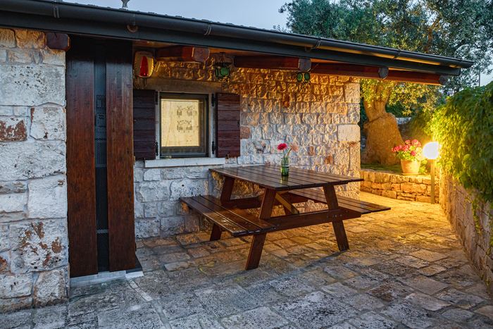 La veranda coperta con il tavolo in legno, al tramonto