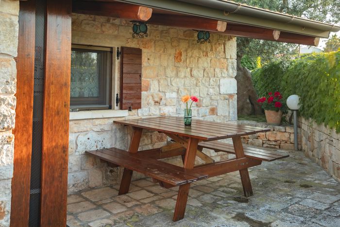 La veranda coperta con tavolo e panche in legno
